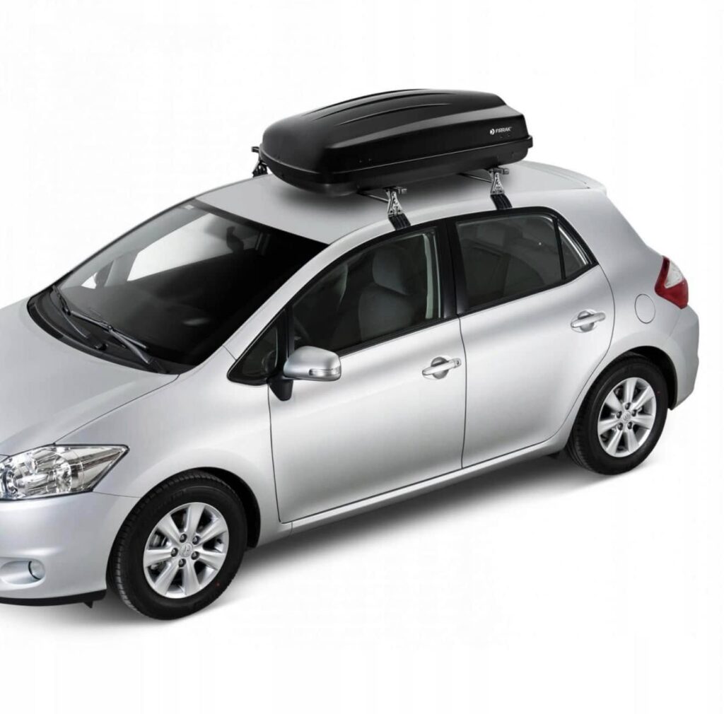 Czarny boks dachowy zamontowany na samochodzie osobowym.